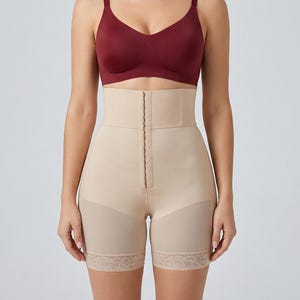 Pode incluir: Sutiã bordô e shorts modeladores de cintura alta bege com fecho frontal e acabamento em renda. Os shorts são projetados para suavizar e modelar a seção intermediária e as coxas. O sutiã tem decote em V e alças ajustáveis.
