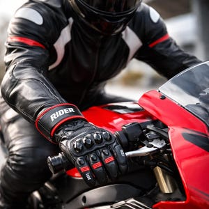Motorcycle rider wearing black leather riding gloves with hard knuckle protection while riding a sport bike