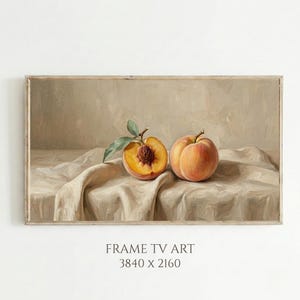 May include: A framed still life painting of two peaches on a draped cloth. One peach is halved, showing the stone. The painting uses a neutral colour palette and soft lighting, creating a vintage aesthetic.