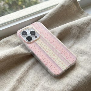 Könnte beinhalten: Handgefertigtes Holzschild mit dem Wort "Welcome" in verspielter Schrift. Das Schild ist weiß lackiert mit einem Used-Look und zeigt ein Blumendesign in Rosa- und Grüntönen. Geeignet für den Innen- und Außenbereich.