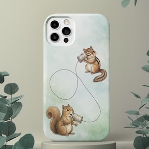 May include: A white phone case featuring a whimsical illustration of two squirrels using tin can phones. The background has a watercolor effect with green and blue hues. The squirrels are brown with striped tails.