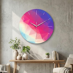 May include: A round wall clock with a vibrant geometric design in shades of pink, purple, and blue. The clock has white hands and simple white markers for the hours. It is mounted on a gray wall.