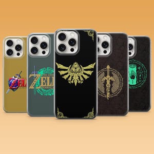 Könnte beinhalten: Fünf Smartphone-Hüllen mit The Legend of Zelda-Motiven. Die Hüllen zeigen verschiedene Grafiken wie das Hylia-Wappen, das Master-Schwert und Spiellogos in Gold, Grün und Schwarz, jeweils mit einem Ausschnitt für die Dreifachkamera.