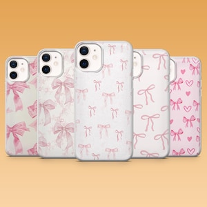 Puede incluir: Cinco fundas para teléfono con diferentes diseños. Las fundas son blancas con lazos rosas, corazones y patrones de mármol. Los lazos son de varios tamaños y arreglos. Para teléfonos inteligentes.