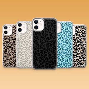 May include: Five phone cases with leopard print patterns in various colours. The cases include black, tan, white, and blue designs. They are made from a clear material with a glossy finish, offering protection and style.