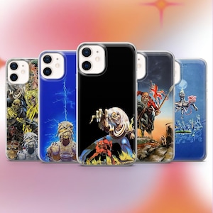 Puede incluir: Se muestran cinco fundas para teléfono con varios diseños gráficos. Las fundas presentan ilustraciones vibrantes, incluyendo una momia, una figura esquelética y una figura con llamas. Las fundas están dispuestas en fila, con una funda negra en el centro.