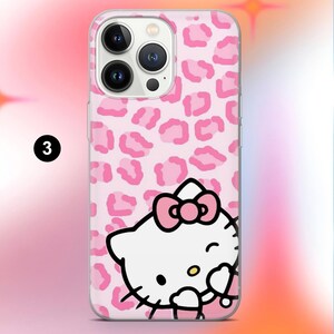 May include: A pink phone case featuring a repeating leopard print pattern and a graphic of Hello Kitty. The Hello Kitty graphic is white with a pink bow and a winking expression. The case is designed to fit a smartphone.
