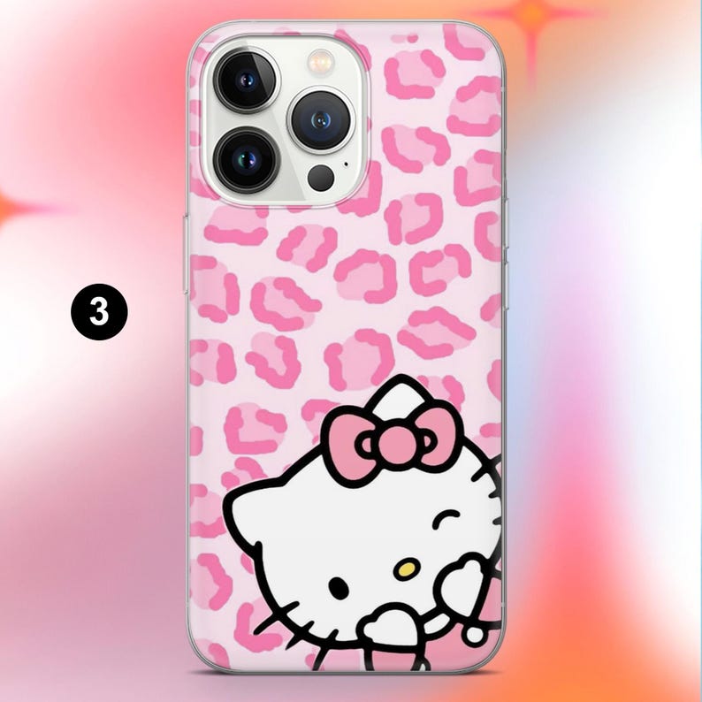 May include: A pink phone case featuring a repeating leopard print pattern and a graphic of Hello Kitty. The Hello Kitty graphic is white with a pink bow and a winking expression. The case is designed to fit a smartphone.