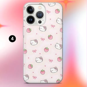 May include: A clear phone case featuring a repeating pattern of cartoon cat faces with bows, strawberries, and pink bows on a light pink background. The phone case has a clear border and a camera cutout.