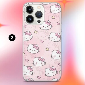 May include: A clear phone case featuring a repeating pattern of Hello Kitty faces with pink bows, hearts, and stars on a pink background. The case has a camera cutout and a number 2 in a black circle.