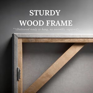 May include: A light-colored wooden frame with a diagonal support brace and a metal sawtooth hanger attached to the side. The text STURDY WOOD FRAME and (Delivered ready to hang, no assembly required) are printed above the frame structure.