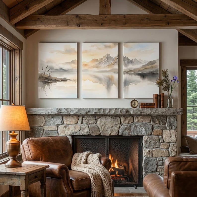 May include: A triptych wall art set featuring a watercolor landscape of misty mountains reflected in a calm lake, rendered in soft beige, gray, and white tones. The three rectangular canvases display a continuous mountain range scene.