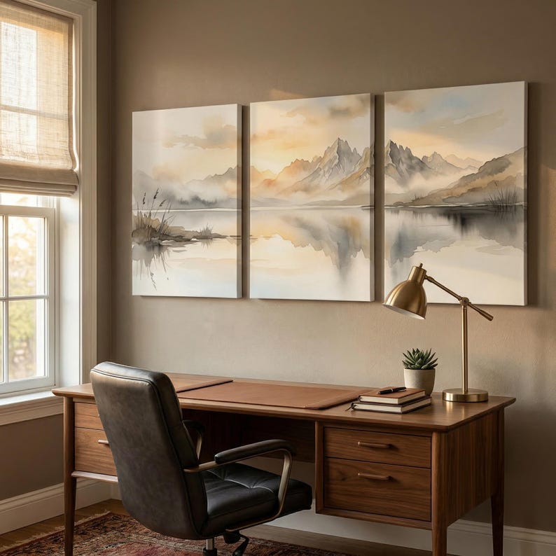 May include: A triptych wall art set featuring a watercolor-style landscape of mountains, a calm lake, and reeds in soft shades of beige, gray, and white. The three rectangular canvases are hung side-by-side, depicting a serene, misty mountain scene.