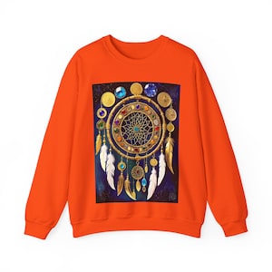Könnte beinhalten: Orangefarbener Pullover mit einem Traumfänger-Design. Der Traumfänger ist goldfarben mit bunten Edelsteinen, Federn und einem Netzmuster. Der Hintergrund ist dunkelblau mit Sterneneffekt.