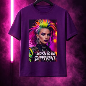 May include: Purple t-shirt featuring a vibrant graphic of a person with rainbow-colored hair and the text "BORN TO BE DIFFERENT." The image has a neon pink background. The t-shirt is hanging on a black hanger.