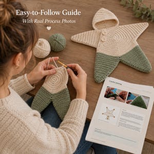 May include: A crochet pattern guide titled Easy-to-Follow Guide With Real Process Photos, featuring a star-shaped hooded garment in cream and sage green yarn. A metal crochet hook works on a matching piece, with yarn balls and a printed instruction sheet.