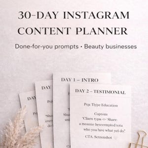 May include: A 30-day Instagram content planner for beauty businesses. The image shows a stack of paper cards with text, including "Day 1 - Intro" and "Day 2 - Testimonial." A gold paper clip and dried flowers are also visible.