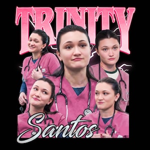 May include: A black t-shirt design featuring multiple images of a person in pink scrubs with a stethoscope. The word "TRINITY" is in pink, stylized text above the images, and the name "Santos" is in white script below.
