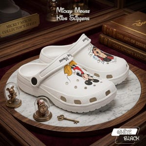 K&ouml;nnte beinhalten: Wei&szlig;e Mickey Mouse Kinder-Hausschuhe mit Mickey Mouse-Grafiken. Die Hausschuhe geh&ouml;ren zur Mickey Mouse Collector's Series. Das Bild enth&auml;lt auch dekorative Elemente und den Text "Mickey Mouse Kids Slippers."