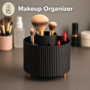 May include: Black makeup organizer with a ribbed design, holding makeup brushes and lipsticks. The organizer has three wooden legs and the text "Makeup Organizer" is visible.