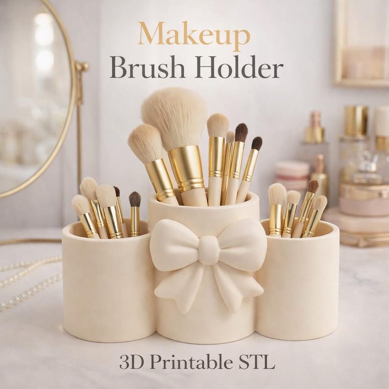 May include: A cream-colored makeup brush holder with three compartments, one featuring a large bow. The holder is filled with various makeup brushes with gold and white handles. The text "Makeup Brush Holder" and "3D Printable STL" are visible.