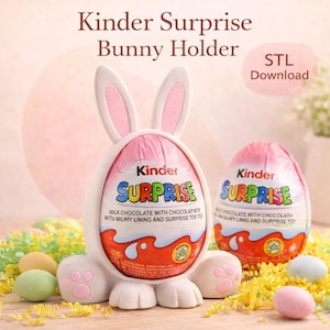 Può includere: Un supporto bianco a forma di coniglio con dettagli rosa tiene un uovo Kinder Sorpresa. L'uovo è avvolto in un involucro rosa con la parola "SURPRISE" a lettere colorate. Il testo recita "Kinder Surprise Bunny Holder" e "STL Download".