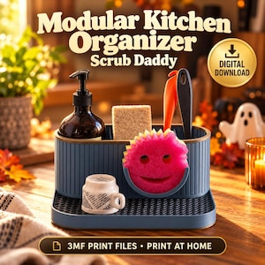 May include: A blue modular kitchen organiser with vertical ribbing, holding a dark soap dispenser, a rectangular sponge, an orange tool, a black tool, and a pink circular smiley-face sponge. A small white mug sits on the front tray.
