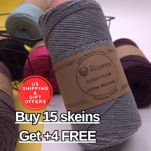 May include: A close-up of a gray cotton macrame yarn skein with a brown label that reads "Rozenne CLASSY FLOW Cotton Macrame Premium Yarns". Other yarn skeins in various colors are visible in the background.