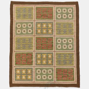 May include: A rectangular rug with a brown border and a grid pattern of squares. Each square contains a different design in shades of green, yellow, red, and gray. The rug is made of woven material.