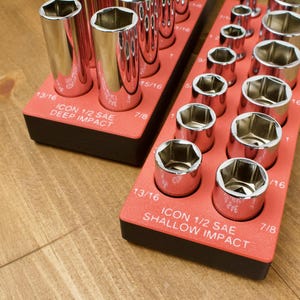 May include: Two red socket organizers with chrome sockets. One is labeled "ICON 1/2 SAE DEEP IMPACT" and the other "ICON 1/2 SAE SHALLOW IMPACT". The sockets are arranged in rows and are various sizes, including 13/16 and 7/8 inch.