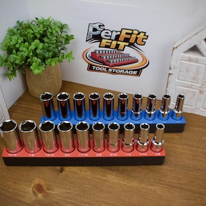Puede incluir: Dos organizadores de llaves de vaso rectangulares con piezas de metal plateado. El organizador delantero es negro con una franja superior roja y contiene diez piezas. El trasero es negro con una franja azul y nueve piezas. Logo PerFit FIT visible.