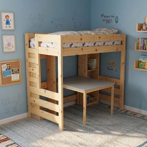 May include: A wooden loft bed with a built-in desk and ladder. The bed frame is made of light-colored wood and has a simple design. The desk is gray and the bed is in a room with light blue walls and a gray rug. There are shelves with books.