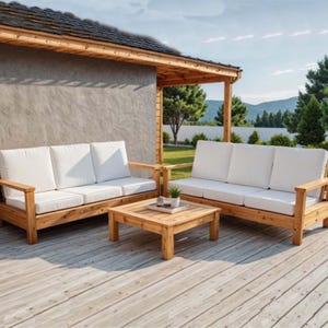 May include: Outdoor wooden furniture set featuring a three-seat sofa, a two-seat sofa, and a square coffee table. The sofas have white cushions and wooden armrests. The set is made of light-colored wood and is placed on a wooden deck.