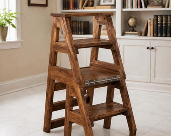 May include: A dark brown wooden step stool with a convertible design. The piece features three distinct levels, including a top platform and two lower steps, connected by a silver metal hinge mechanism that allows the structure to fold and unfold.