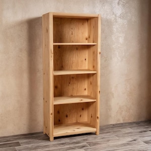 May include: A tall, unfinished wooden bookshelf with four shelves. The natural wood grain is visible throughout the structure. The bookshelf is rectangular and stands upright, ready for use in a home or office setting.
