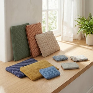 Puede incluir: Una colección de cojines decorativos cuadrados y rectangulares en varios colores y patrones. Los cojines incluyen colores lisos, pana, lunares y diseños acolchados. La paleta de colores incluye verde, beige, amarillo, azul y rojo.