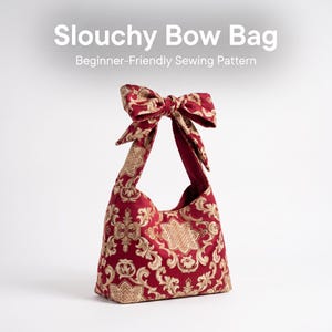 May include: A slouchy bow bag with a red and gold damask pattern. The bag features a large tied bow at the top of the handle. Text above the bag reads Slouchy Bow Bag Beginner-Friendly Sewing Pattern. The bag has a structured base and open top.
