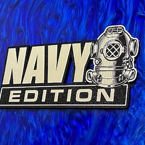 May include: A wooden sign with the words "Navy Edition" in gold lettering on a black background. A vintage diving helmet is depicted to the right of the text.