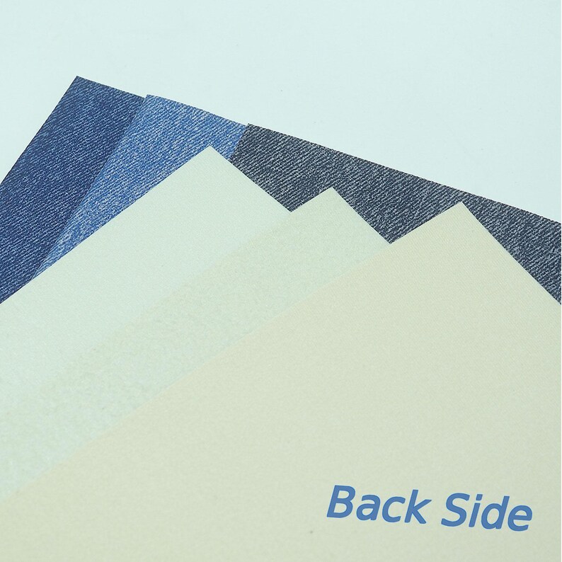 May include: A collection of textured paper samples in shades of blue and cream. The samples are arranged in a layered pattern, with the text "Back Side" printed in blue.