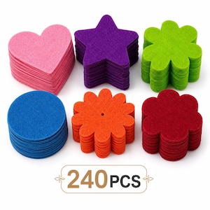 Puede incluir: Una colección de 240 formas de fieltro en seis diseños y colores distintos, que incluyen corazones rosas, estrellas moradas, flores verde lima, círculos azules, flores naranjas con un orificio central y flores de color rojo oscuro, apiladas.