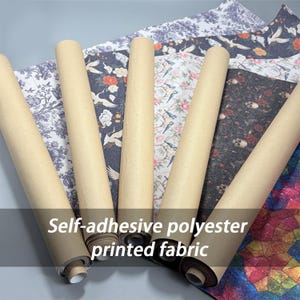 May include: Five rolls of self-adhesive polyester printed fabric featuring various patterns including blue and white toile, black with cranes and flowers, floral with birds, black with skulls and roses, and a colorful geometric stained glass design.