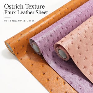 May include: Three rolls of faux leather sheets featuring an ostrich texture in shades of tan, purple, and light pink. The text Ostrich Texture Faux Leather Sheet For Bags, DIY & Decor is printed on the left side of the image.