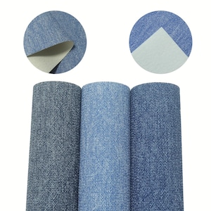 Può includere: Tre rotoli di tessuto denim in diverse tonalità di blu. Il tessuto ha un aspetto strutturato, con viste circolari ravvicinate che mostrano il retro del materiale. I rotoli sono disposti verticalmente, mostrando i diversi lavaggi di denim.