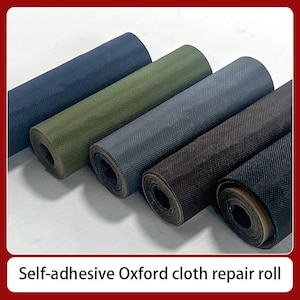 May include: Several rolls of self-adhesive Oxford cloth repair material in various colors, including navy blue, olive green, and black. The rolls are tightly wound and ready for use. The text "Self-adhesive Oxford cloth repair roll" is visible.