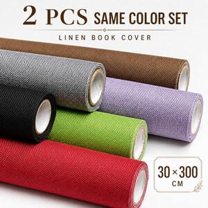 Può includere: Un set di due copertine per libri in lino di vari colori, tra cui marrone, grigio, nero, viola chiaro, verde lime e rosso. I rotoli presentano una superficie in tessuto testurizzato e riportano le scritte 2 PCS SAME COLOR SET e 30 x 300 CM.