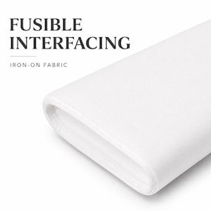 May include: A roll of white fusible interfacing fabric. The text "FUSIBLE INTERFACING" and "IRON-ON FABRIC" are displayed in the upper left corner. The fabric is tightly rolled, showing the layers of the material.