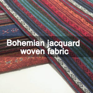 Könnte beinhalten: Ein gewebter Stoff mit einem mehrfarbigen Streifenmuster und geometrischen Rautenmotiven in Rot, Blau, Grün und Weiß. Das Textil zeigt den Text Bohemian jacquard woven fabric in einer klaren weißen Schrift auf der Oberfläche.