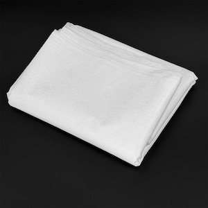 May include: A folded stack of white tissue paper, likely for wrapping gifts or protecting delicate items. The paper has a slightly textured surface and is neatly arranged, creating a clean and organized appearance. The background is a solid black.