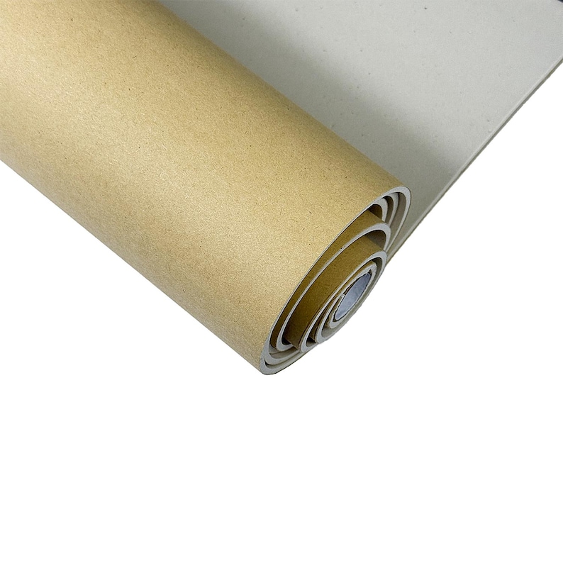 May include: A rolled-up sheet of tan-coloured paper or mat, revealing its layered edge. The paper has a smooth texture and a neutral hue, ideal for craft or artistic endeavours. The background is white.