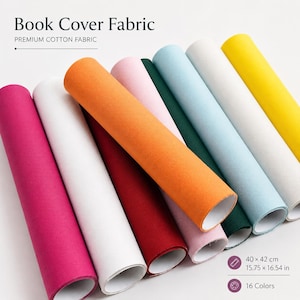 Op de afbeelding: Een collectie opgerolde katoenen stoffen vellen voor boekomslagen, in 16 kleuren waaronder magenta, wit, oranje, rood, roze, donkergroen, lichtblauw en geel. Elk vel meet 40 bij 42 cm, gelabeld als Book Cover Fabric.